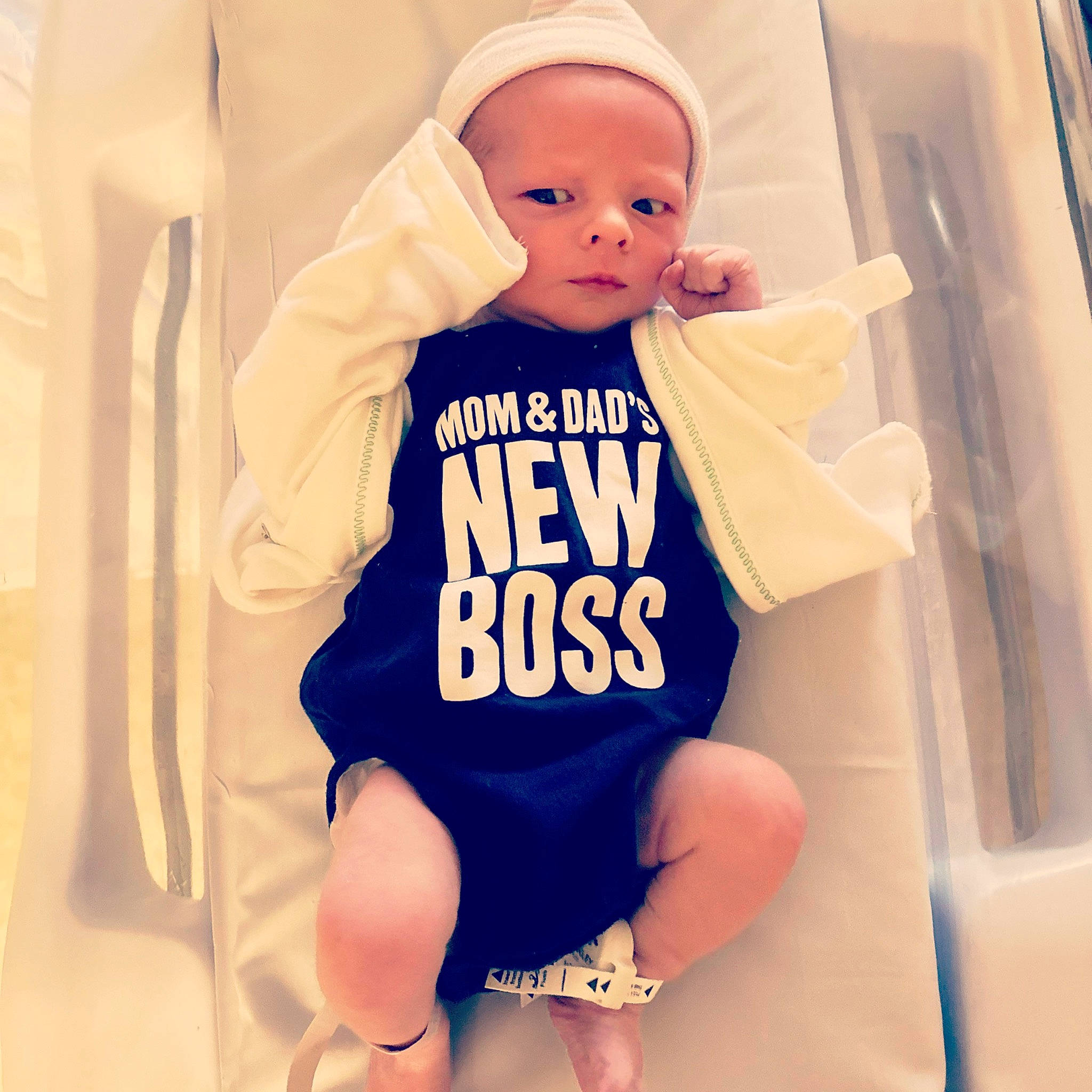 Travis is registered to the contest to win money with this photo: baby, baby_products, baby_safety, baby_sleeping, baby_toddler_clothing, cap, face, finger, font, happy, human_body, knee, neck, person, sleeve, sportswear, t_shirt, thigh, thumb, toddler