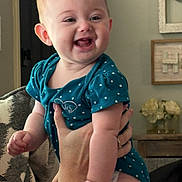 Karter Jane is registered to the contest to win money with this photo: baby, child, smiling, indoor, person, hand, clothing, polka_dot, holding, happy, face, infant, furniture, cushion, home_decor, diaper, sleeve, skin, adult_hand, portrait