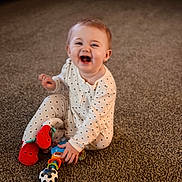 Karter Jane is registered to the contest to win money with this photo: baby, carpet, child, colorful_toy, cute, face, feet, hands, happy, indoor, infant, laughing, playtime, polka_dot_pajamas, portrait, sitting, smiling, strawberry_slippers, toy, warm_lighting