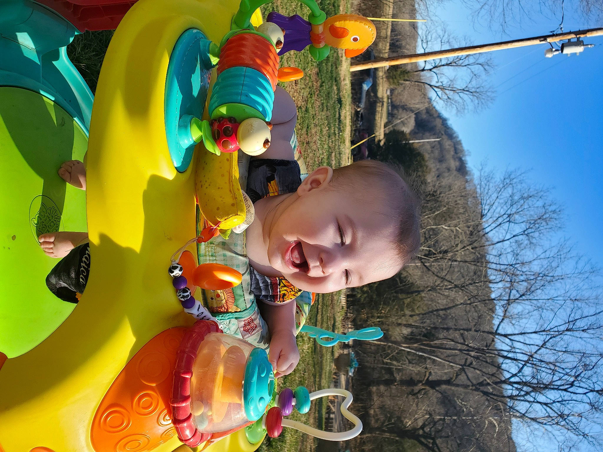 Rosalie is registered to the contest to win money with this photo: baby, child, fun, grass, happy, leaf, leisure, people_in_nature, person, photograph, play, recreation, sky, smile, snapshot, toddler, toy, tree, twig, water