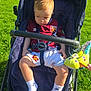 toddler, child, stroller, outdoor, park, grass, sunlight, west_ham_jersey, football, toy, plush, blue, white_socks, nike, footwear, baby_clothing, summer, daylight, person, casual