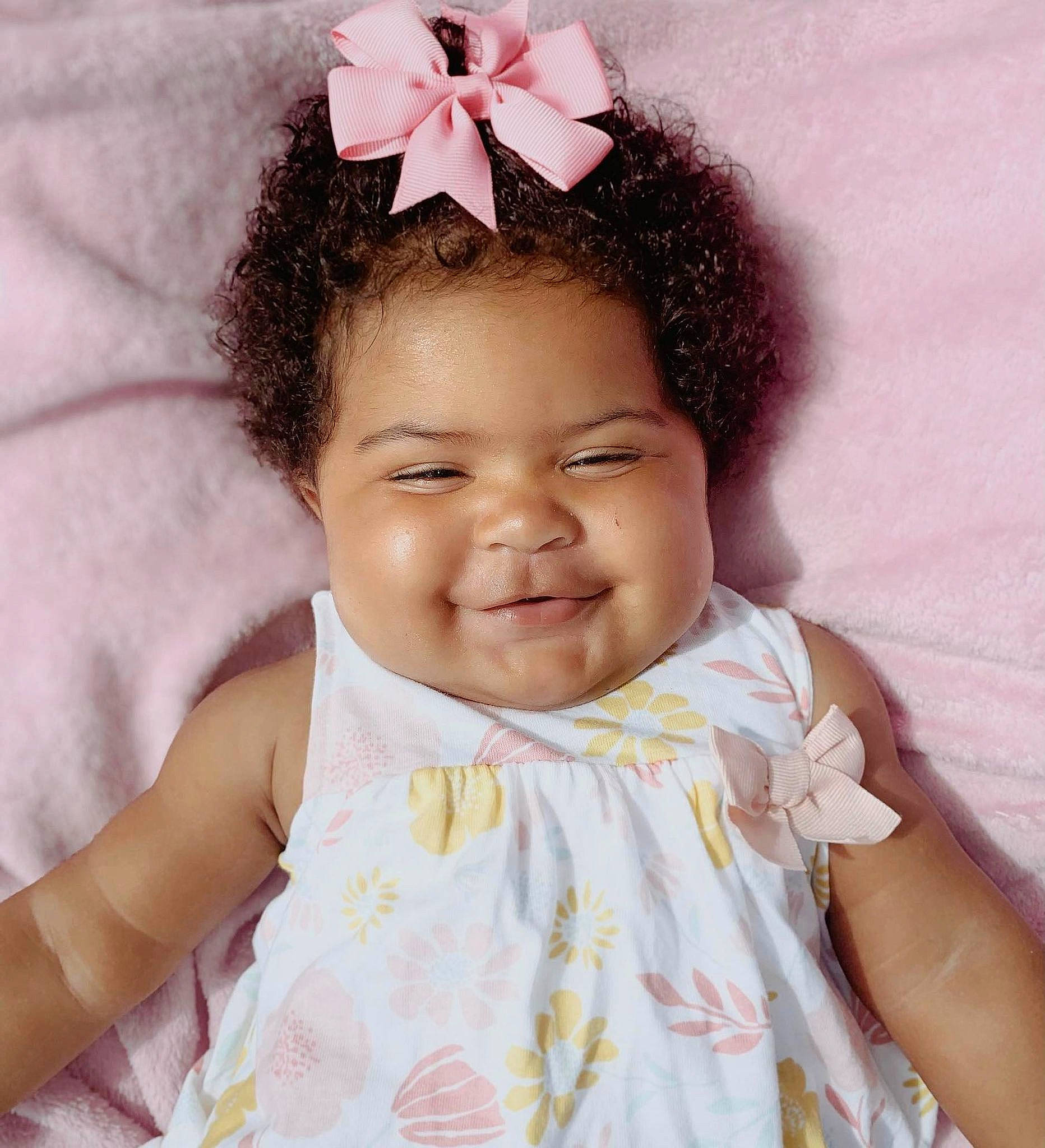 Leila is registered to the contest to win money with this photo: baby, baby_toddler_clothing, beauty, child, chin, eyelash, face, happy, headgear, headpiece, joy, magenta, pattern, person, petal, pink, purple, skin, sleeve, smile