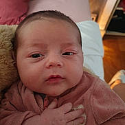 Gabrielle a rejoint le concours — aidez-le/la à gagner de superbes lots ! baby, infant, face, hand, pink_clothing, indoor, closeup, sleepy, soft_texture, human, newborn, child, portrait, cute, resting, warm_lighting, cozy, young_child, person, casual