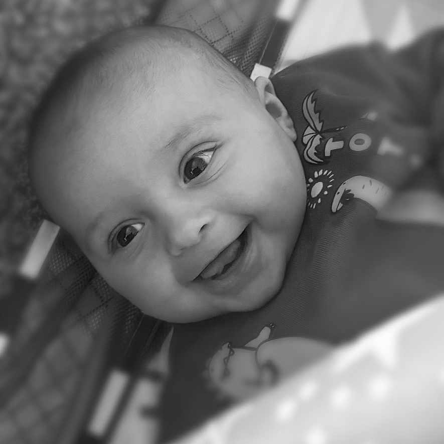 Reuben is registered to the contest to win money with this photo: baby, black_and_white, blanket, child, closeup, clothing, crib, cute, eyes, face, happy, indoors, infant, playpen, portrait, smile, soft_focus, star_pattern, tongue, young