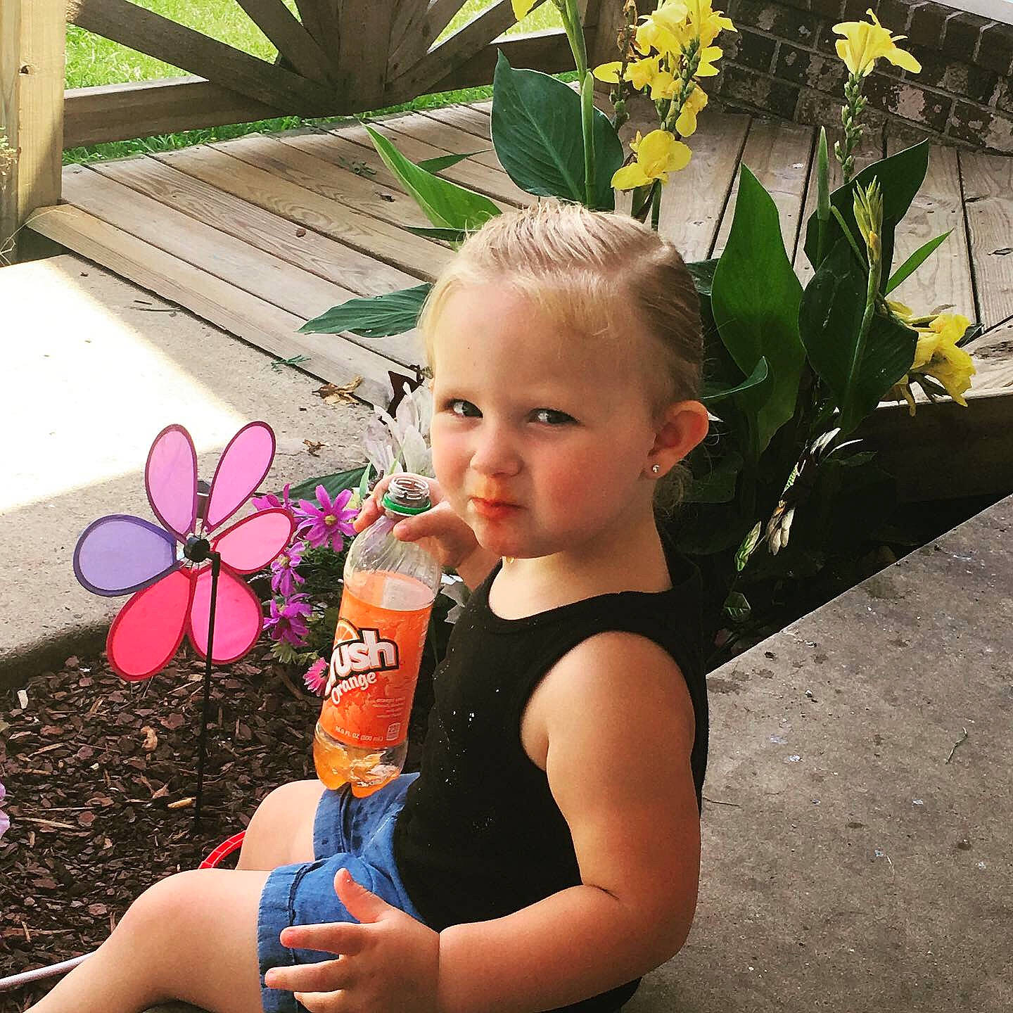 Kenslee is registered to the contest to win money with this photo: auto_part, automotive_wheel_system, botany, child, flower, fun, happy, iris, leg, person, plant, smile, spring, summer, toddler, vacation, wheel