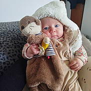 Lou a rejoint le concours — aidez-le/la à gagner de superbes lots ! baby, infant, blue_eyes, hooded_coat, plush_monkey, stuffed_toy, corduroy_overall, floral_shirt, hand, couch, blanket, portrait, indoor, soft_texture, cute, chubby_cheeks, sitting, toy, hood, cozy