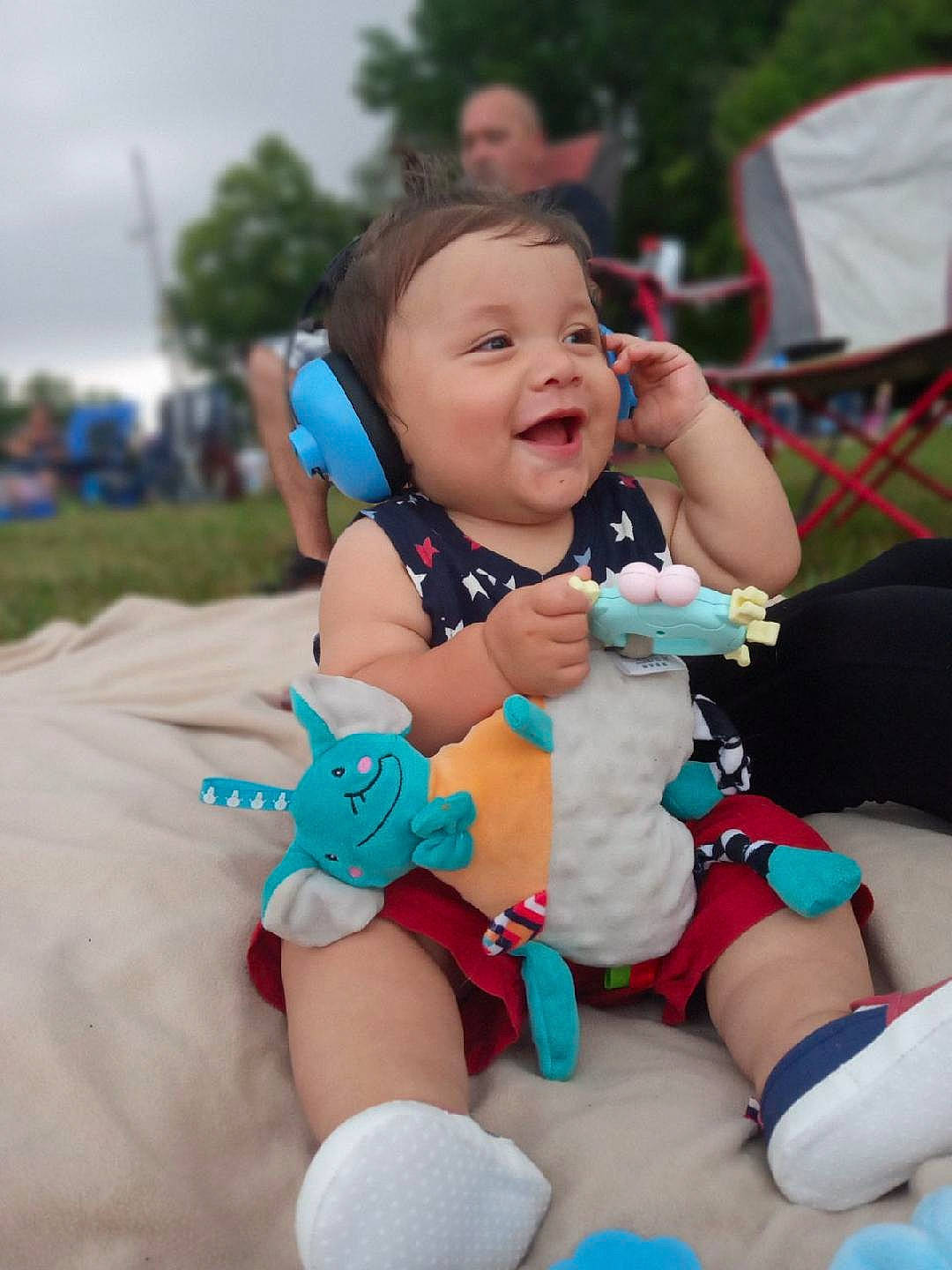 Declyn is registered to the contest to win money with this photo: abdomen, baby, baby_toddler_clothing, blurred, child, event, fun, grass, happy, headwear, human_leg, lap, leisure, person, pink, recreation, sitting, skin, smile, thigh