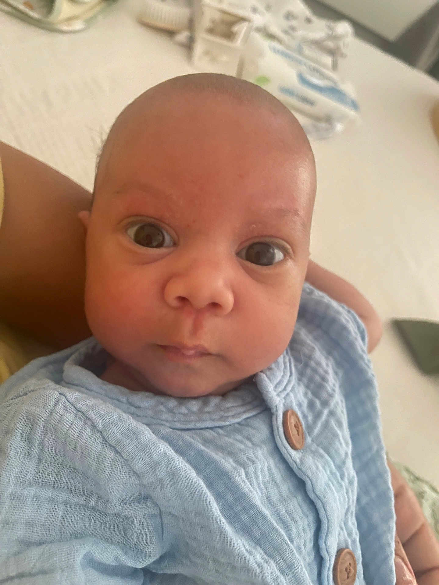 Mayssan participe au concours pour gagner de l'argent avec cette photo : baby, infant, face, eyes, clothing, blue, buttoned_shirt, person, portrait, skin, head, closeup, indoor, newborn, cute, expression, curious, child, soft_light, human