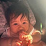 Faith is registered to the contest to win money with this photo: adorable, baby, bracelet, child, closeup, clothing, curly_hair, cute, expression, foot, hand, indoors, infant, nibbling, person, portrait, sitting, skin, sunlight, warm_light
