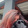 person, dog, black_dog, pet, animal, closeup, portrait, hair, face, snuggle, companion, outdoor, garage, roof, window, expression, friendship, calm, affection, natural_light