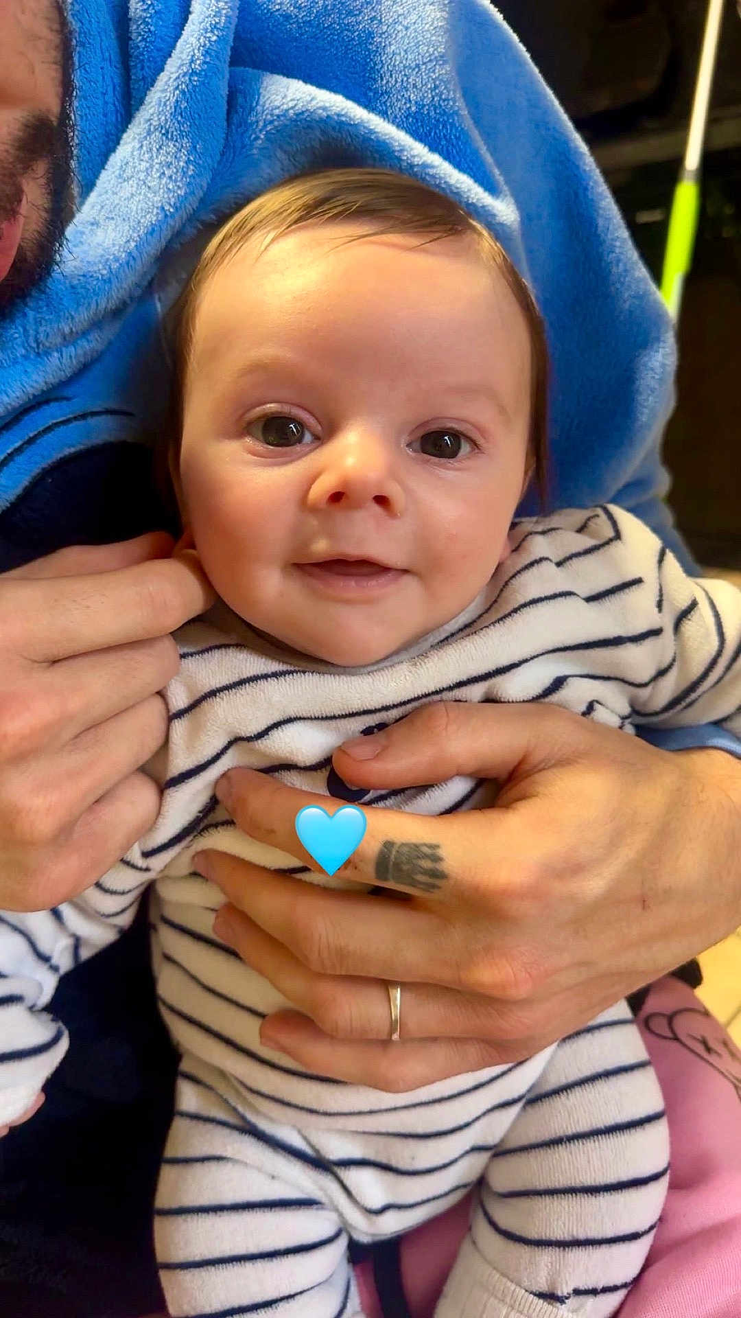 Milan a rejoint le concours — aidez-le/la à gagner de superbes lots ! baby, infant, smile, striped_onesie, blue_blanket, tattoo, wedding_ring, adult_hand, hands, big_eyes, close_up, portrait, indoor, cute, cuddling, emoji_heart, soft_fabric, person, face, holding