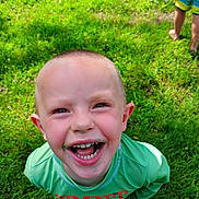Lucas joined the competition — help win amazing prizes! child, smiling, grass, barefoot, green_shirt, outdoor, happy, playful, boy, short_hair, messy_face, daylight, nature, fun, summer, toy, container, background, person, close_up