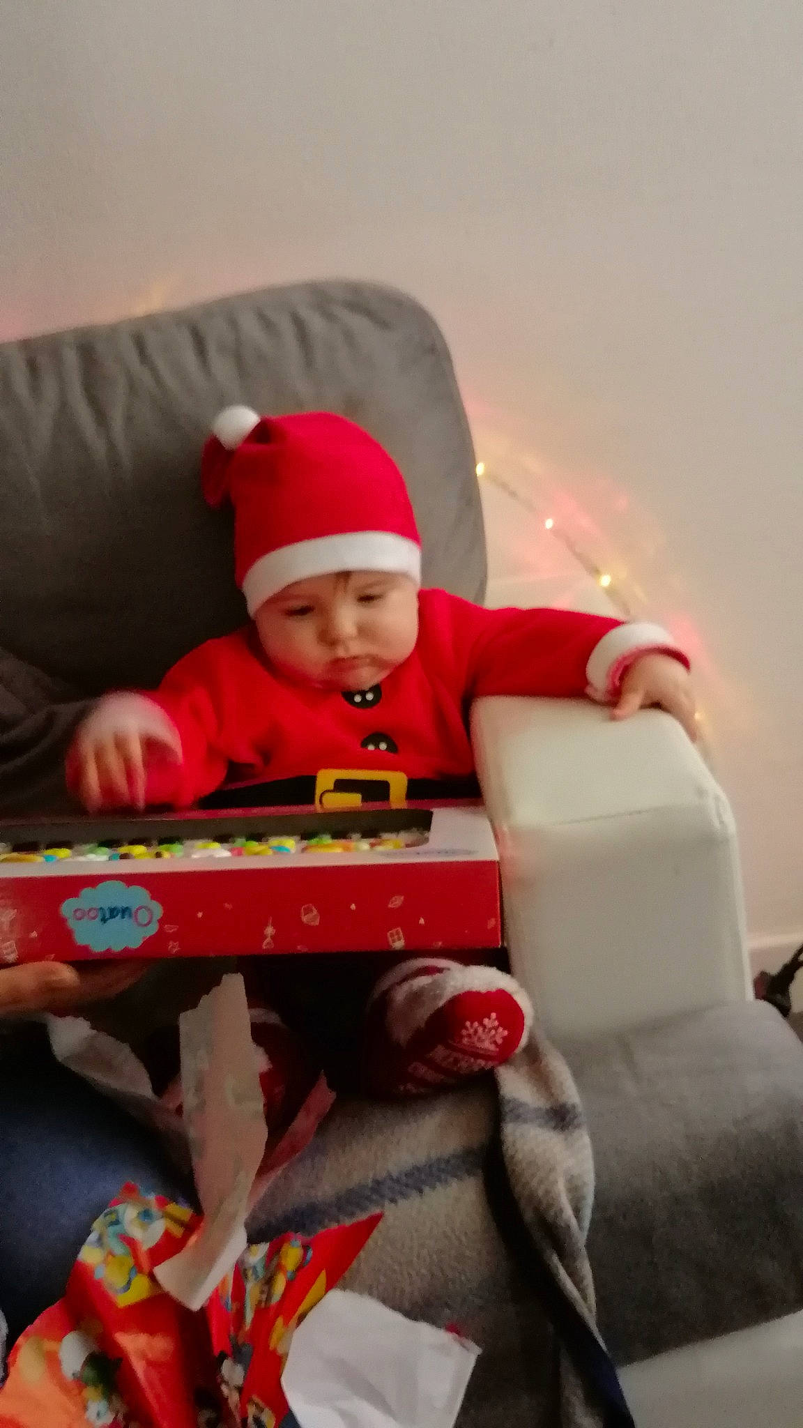 Jayden participe au concours pour gagner de l'argent avec cette photo : baby, baby_playing_with_toys, baby_products, baby_toddler_clothing, baby_toys, beanie, carmine, child, christmas, comfort, couch, headwear, lap, person, play, red, sitting, toddler