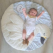 Isaac participe au concours pour gagner de l'argent avec cette photo : baby, infant, child, swan_mat, floor, white_outfit, brown_shoes, raised_arms, smiling, happy, indoor, soft_mat, cute, two_months, baby_bib, plush, patterned_mat, light_floor, baby_pose, baby_face