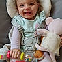 baby, child, smile, happy, toy, stuffed_animal, pigtails, seat_belt, baby_seat, cushion, infant, play, cute, indoors, clothing, hand, face, person, pink, colorful