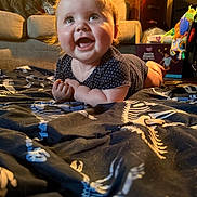 Nikkyta joined the competition — help win amazing prizes! baby, smiling, indoor, blanket, dinosaur_pattern, couch, dog, toy, furniture, child, happy, cute, portrait, infant, living_room, clothing, person, face, colorful, home