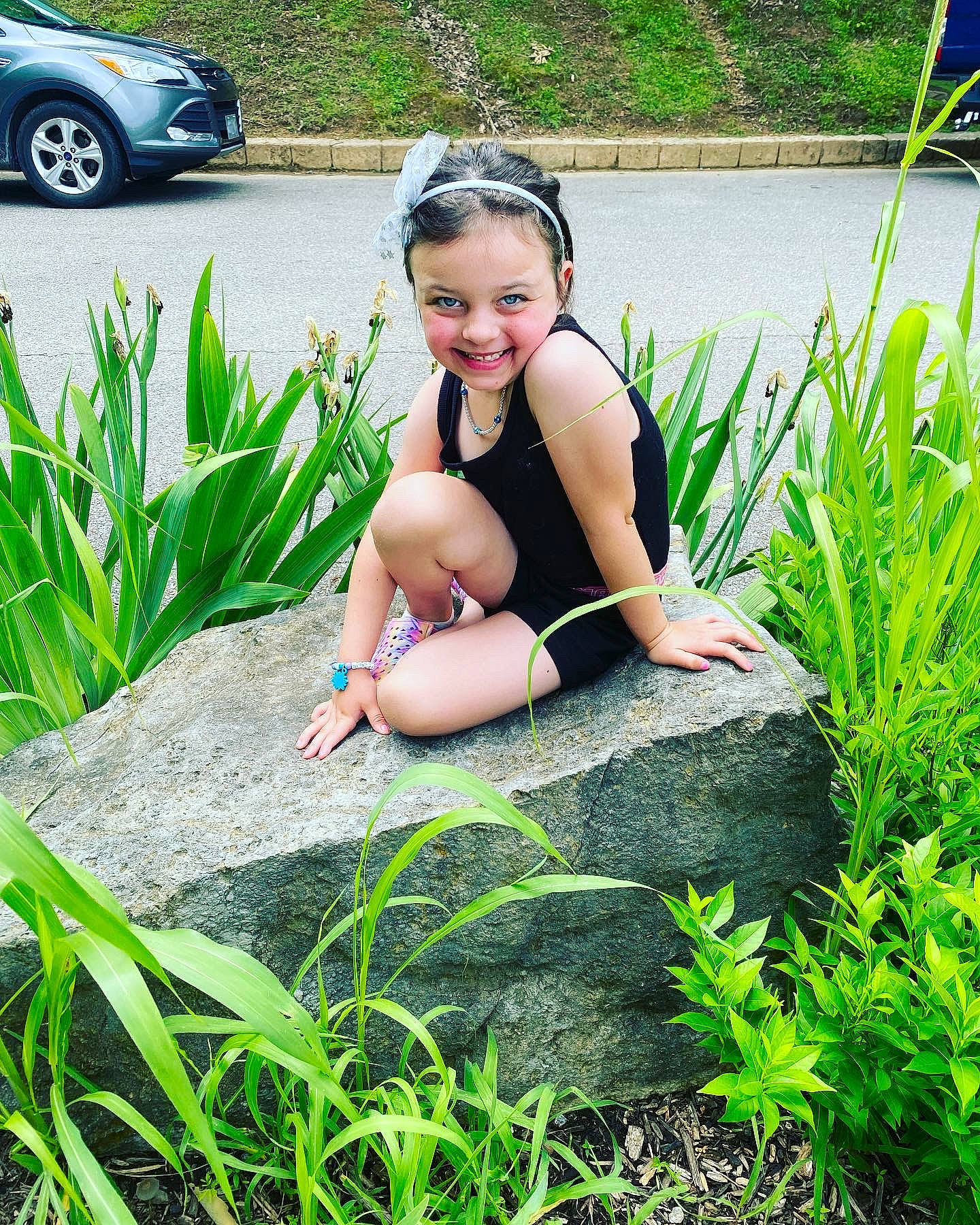 Noralie is registered to the contest to win money with this photo: barefoot, car, fun, grass, grass_family, happy, human_leg, joy, landscape, lawn, leg, leisure, people_in_nature, person, plant, sitting, smile, summer, thigh, tire