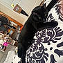 cat, black_cat, bed, bedspread, patterned_bedspread, indoor, furniture, fan, door, relaxed, animal, pet, sleeping, cozy, home, domestic, resting, curious, fur, whiskers