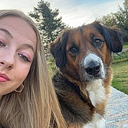 Perle participe au concours pour gagner de l'argent avec cette photo : dog, dog_face, person, woman, selfie, outdoor, sky, tree, grass, stone_surface, fur, portrait, ears, eyes, nose, gold_hoop_earring, makeup, smiling, park, bench