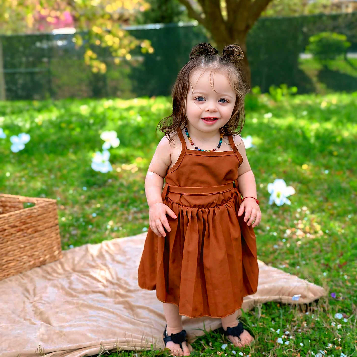 Journei Aliviah is registered to the contest to win money with this photo: barefoot, basket, blanket, brown_dress, child, daylight, dress, garden, girl, grass, hair_buns, happy, nature, necklace, outdoor, portrait, smiling, sunlight, toddler, tree