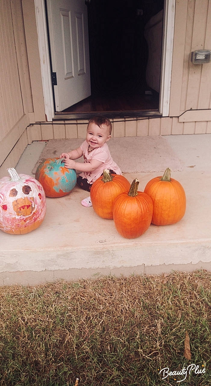 Amaiyah is registered to the contest to win money with this photo: calabaza, child, cucurbita, floor, flooring, food, fruit, gourd, joy, orange, person, plant, produce, pumpkin, toddler, vegetable, vegetarian_food, winter_squash
