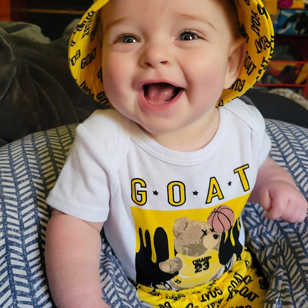 Daniel is registered to the contest to win money with this photo: baby, bodypart, bonnet, cap, clothing, costume, face, finger, hand, happy, hat, head, hood, laughing, person, photography, portrait, smile, sunhat, t_shirt