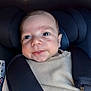 Andréa participe au concours pour gagner de l'argent avec cette photo : baby, infant, car_seat, child, seat_belt, smile, face, eyes, clothing, beige, close_up, sitting, young_child, child_seat, head_support, portrait, cute, baby_clothes, indoor, straps