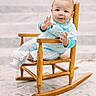 baby, child, rocking_chair, wooden_chair, blue_clothing, plaid_overalls, white_shoes, curious_expression, short_hair, outdoor, steps, stone_floor, sitting, infant, cute, portrait, young_child, hand_gesture, daylight, casual_wear