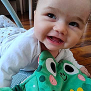 Lenny participe au concours pour gagner de l'argent avec cette photo : baby, smiling, infant, plush_toy, frog_toy, floor, indoors, happy, child, cute, clothing, white_shirt, toy, playtime, face, head, expression, closeup, person, toddler