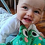 baby, smiling, infant, plush_toy, frog_toy, floor, indoors, happy, child, cute, clothing, white_shirt, toy, playtime, face, head, expression, closeup, person, toddler