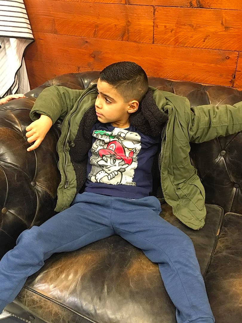 Gabriel participe au concours pour gagner de l'argent avec cette photo : black_hair, child, cool, furniture, human, jacket, jeans, person, sitting