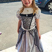 Yuna participe au concours pour gagner de l'argent avec cette photo : child, girl, smiling, dress, princess_costume, outdoor, daylight, car, house, pavement, shadow, happy, person, long_hair, white_dress, black_lace, standing, sunlight, casual, portrait