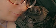 Lilith joined the competition — help win amazing prizes! affection, casual_clothing, cat, close_up, cozy, cute, eyewear, face, glasses, hat, indoor, knit_hat, person, portrait, resting, sleepy_cat, snuggling, tabby_cat, tattoo, warm