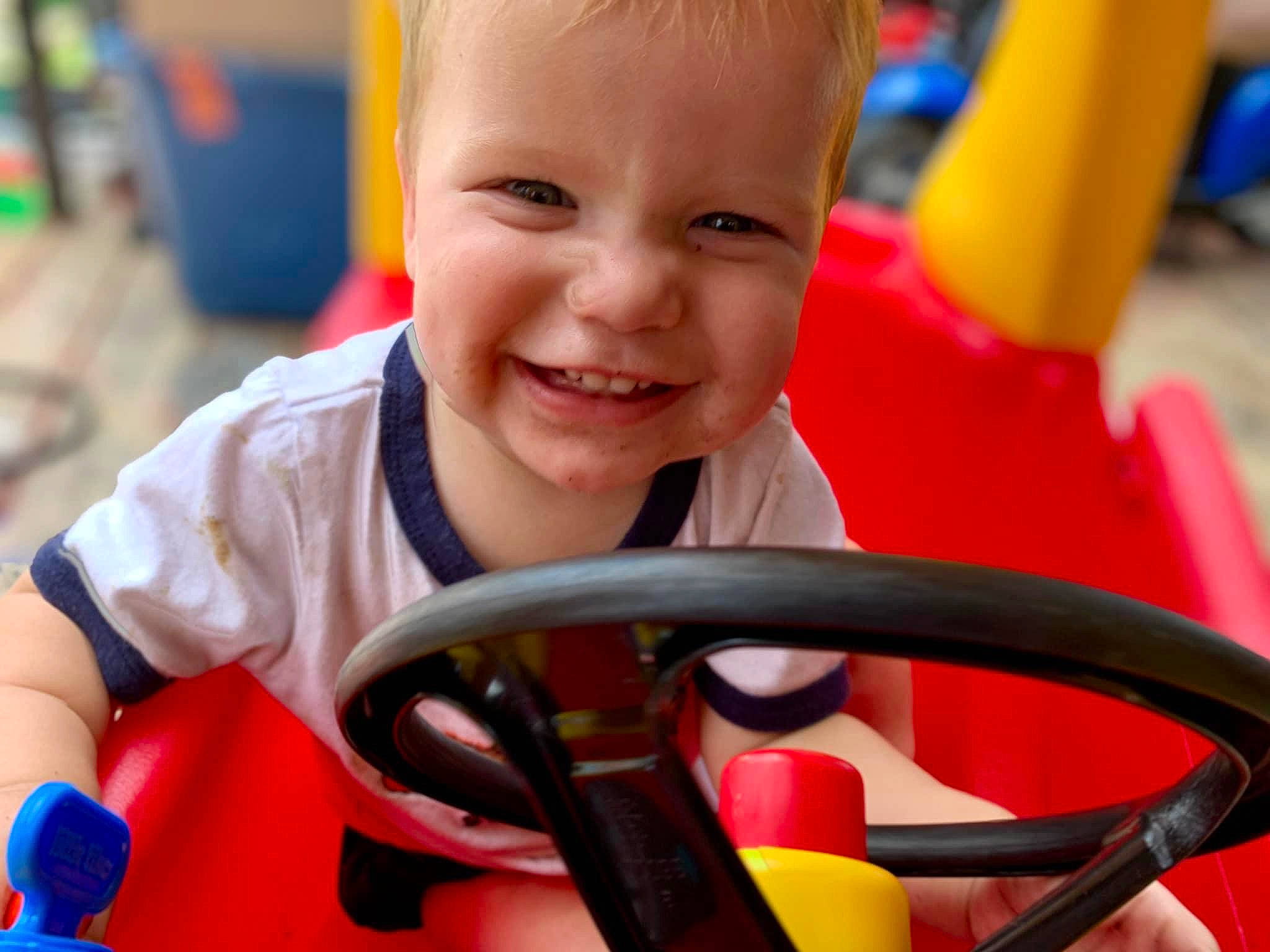 Christen joined the competition — help win amazing prizes! baby_playing_with_toys, child, facial_expression, fun, hand, happy, human_settlement, joy, leisure, motor_vehicle, organ, person, photograph, product, recreation, red, riding_toy, smile, snapshot, toddler
