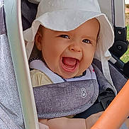 Anna participe au concours pour gagner de l'argent avec cette photo : baby, baby_clothing, baby_seat, child, closeup, cute, daylight, expressive, face, happy, hat, infant, joy, outdoor, person, portrait, seatbelt, smiling, stroller, sunhat