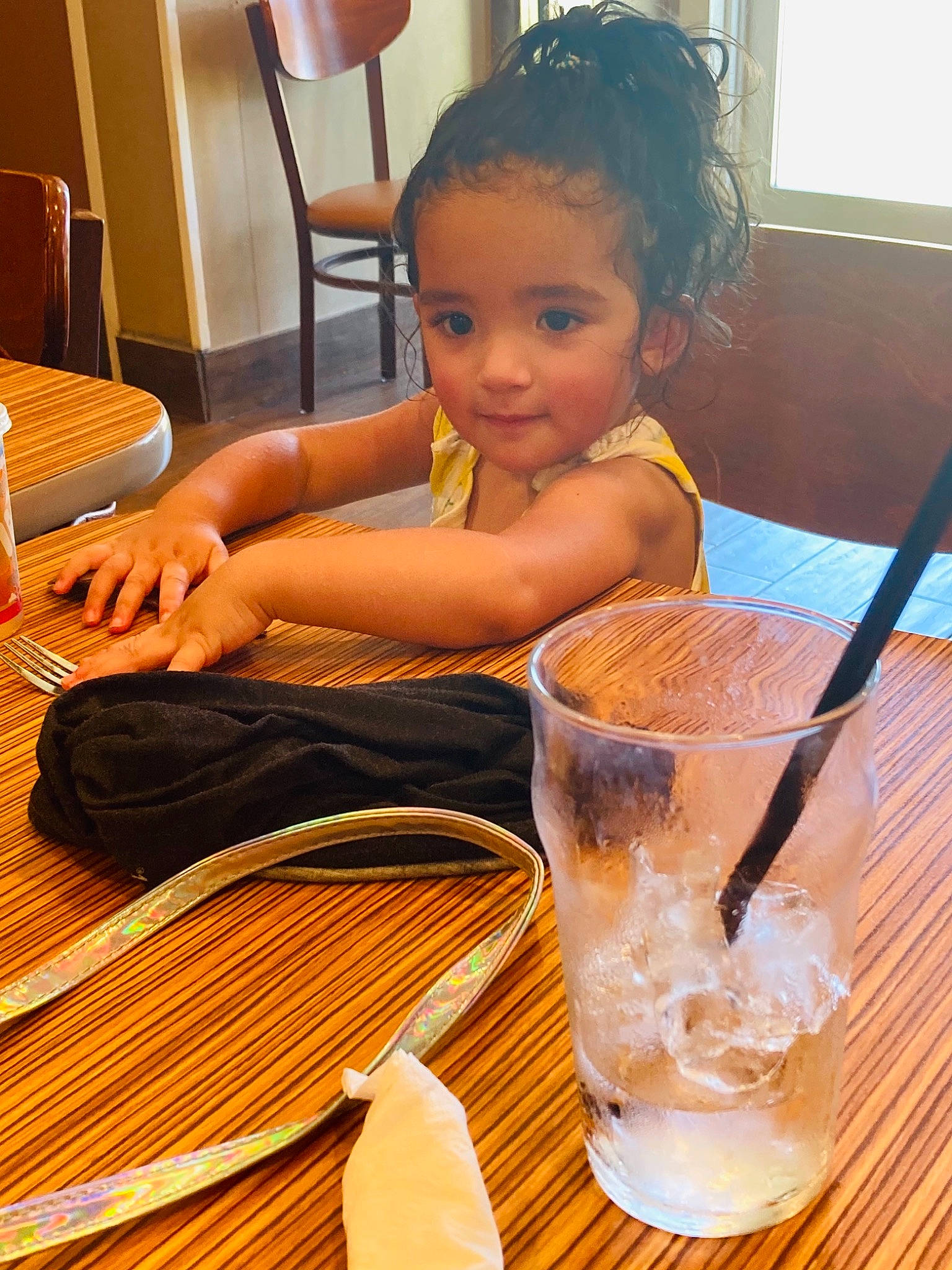 Kayleighn is registered to the contest to win money with this photo: chair, child, cutlery, drink, drinkware, floor, flooring, food, hardwood, kitchen_utensil, person, plate, serveware, sitting, table, tableware, toddler, varnish, water, wood