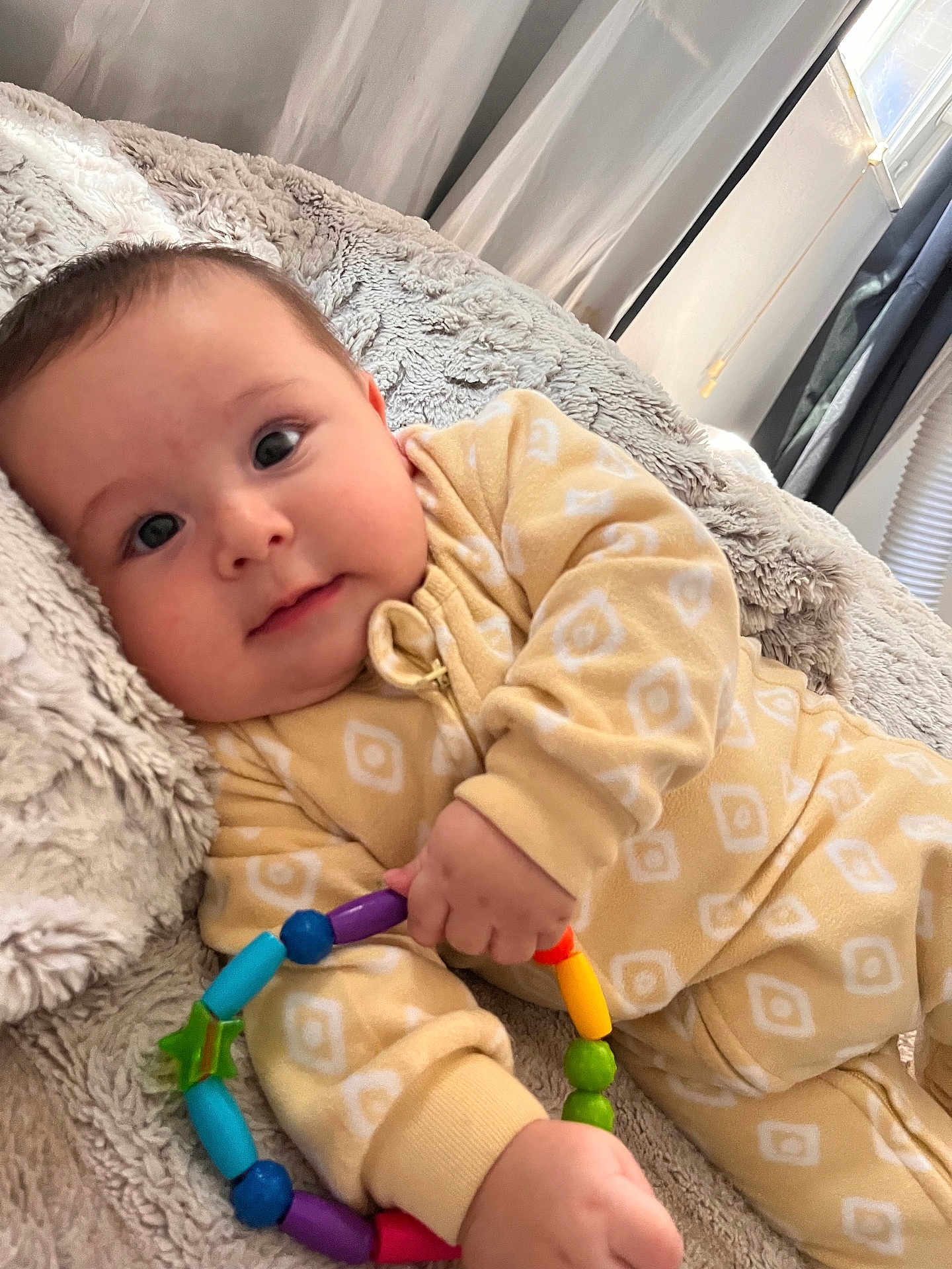 Theodore is registered to the contest to win money with this photo: baby, infant, toy, colorful, onesie, blanket, soft, cute, child, indoors, smile, face, hand, play, comfort, couch, warm, relaxed, portrait, young