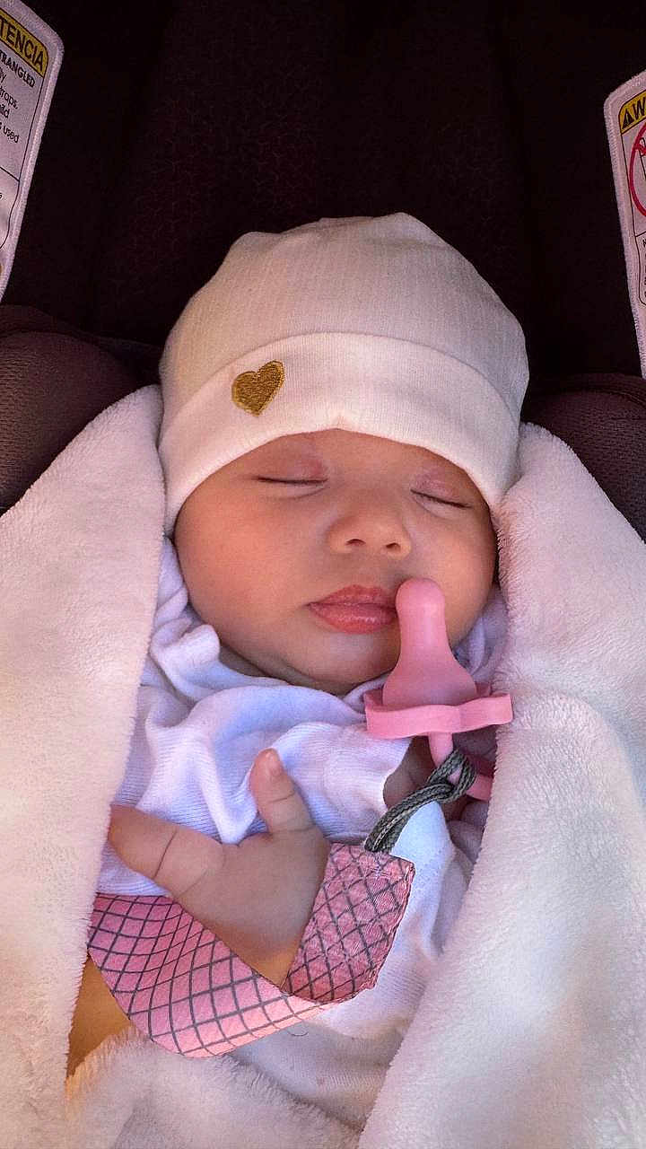 Aliya is registered to the contest to win money with this photo: baby, sleeping, pacifier, blanket, hat, infant, cute, peaceful, soft, cozy, child, newborn, wrapped, resting, pink, white, closeup, face, hand, carseat