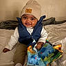 Denim joined the competition — help win amazing prizes! baby, child, smile, hat, vest, bed, blanket, toy, soft_book, indoor, happy, person, clothing, cute, infant, play, colorful, cozy, portrait, warm_lighting