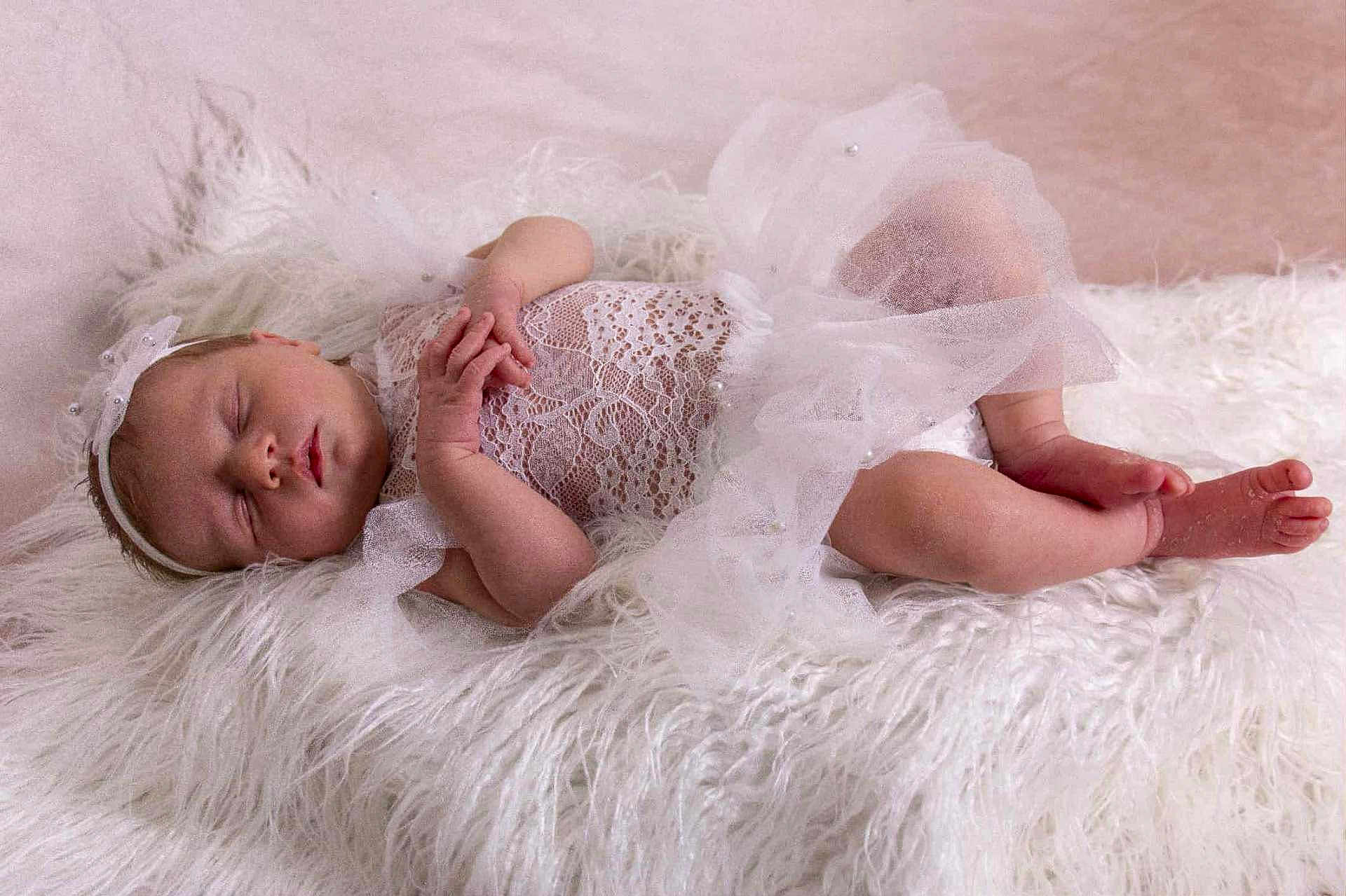 Layla is registered to the contest to win money with this photo: baby, newborn, sleeping, white_lace, tulle, headband, fluffy, soft_texture, infant, peaceful, cute, portrait, resting, delicate, small_hands, small_feet, indoors, cozy, sleep, baby_clothing