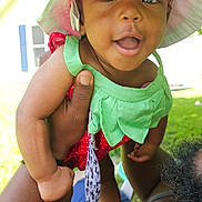 Ellagrace is registered to the contest to win money with this photo: baby, child, outdoor, greenery, sunhat, red_clothing, green_clothing, pacifier, hand, smiling, happy, infant, person, playing, summer, daylight, grass, skin, holding, nature