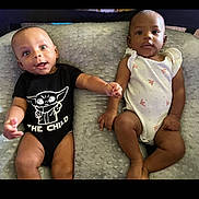 Elias joined the competition — help win amazing prizes! baby, infant, child, onesie, blanket, holding_hands, lying_down, cute, adorable, two_babies, black_onesie, white_onesie, patterned_clothing, soft_texture, indoor, portrait, face, expression, calm, curious