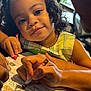 Olive joined the competition — help win amazing prizes! activity_sheet, adult_hand, child, coloring, crayon, curly_hair, dress, education, face, girl, hand, indoor, learning, natural_light, paper, person, plaid, smile, table, window