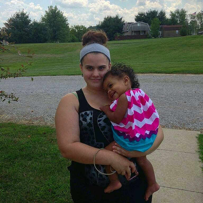 Ariel joined the competition — help win amazing prizes! child, clouds, colorful_clothing, curly_hair, daylight, dress, family, grass, happy, headband, holding, nature, outdoor, person, residential_area, sidewalk, sky, smile, toddler, woman