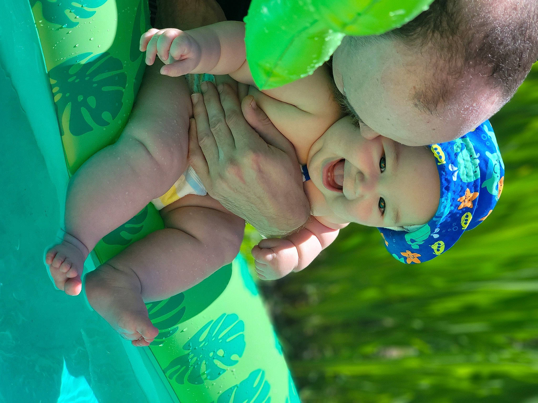 Charlie is registered to the contest to win money with this photo: aqua, arm, azure, cool, electric_blue, finger, fun, gesture, grass, green, hand, happy, headwear, leisure, people_in_nature, person, plant, recreation, shorts, toddler