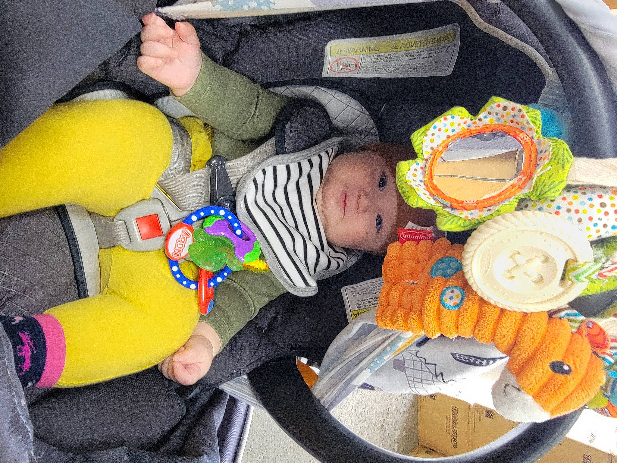 Charlie is registered to the contest to win money with this photo: baby, baby_carriage, baby_products, baby_toddler_clothing, baby_toys, car_seat, child, comfort, fun, hand, headwear, lap, orange, person, play, product, room, sitting, stuffed_toy, toddler