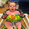 Ainsley is registered to the contest to win money with this photo: baby, child, baby_walker, pink_clothing, pony_tail, toy, indoor, wooden_floor, couch, colorful, expression, face, person, footwear, socks, seat, playroom, happy, infant, furniture