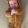 baby, infant, smiling, bear_costume, fuzzy_clothing, cute, hands_clasped, lying_down, soft_surface, happy, child, portrait, one_person, indoors, warm_clothing, baby_face, adorable, cozy, infant_clothing, expression