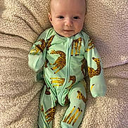 Archie joined the competition — help win amazing prizes! baby, infant, onesie, giraffe_print, blanket, soft_texture, lying_down, cute, smiling, child, young, indoors, comfortable, clothing, pattern, portrait, face, head, small_hands, feet