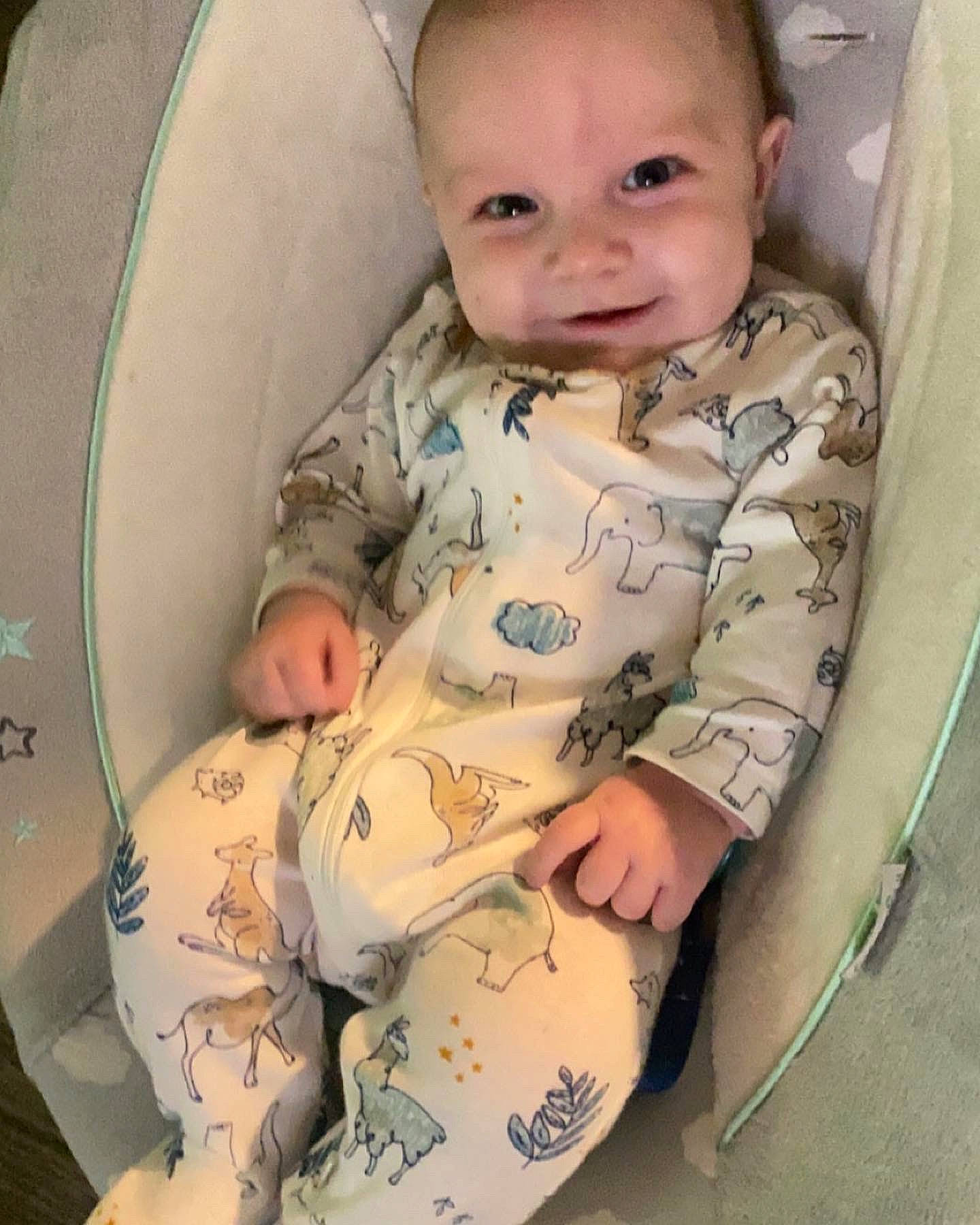 Archer is registered to the contest to win money with this photo: arm, baby, baby_products, baby_toddler_clothing, cheek, child, chin, comfort, eye, face, hand, head, human_body, leg, pattern, person, sitting, skin, sleeve, smile